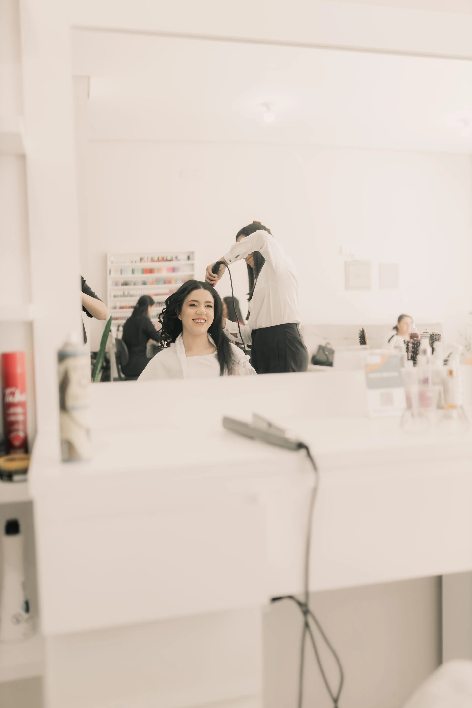 Hairdresser styling a client in a bright salon