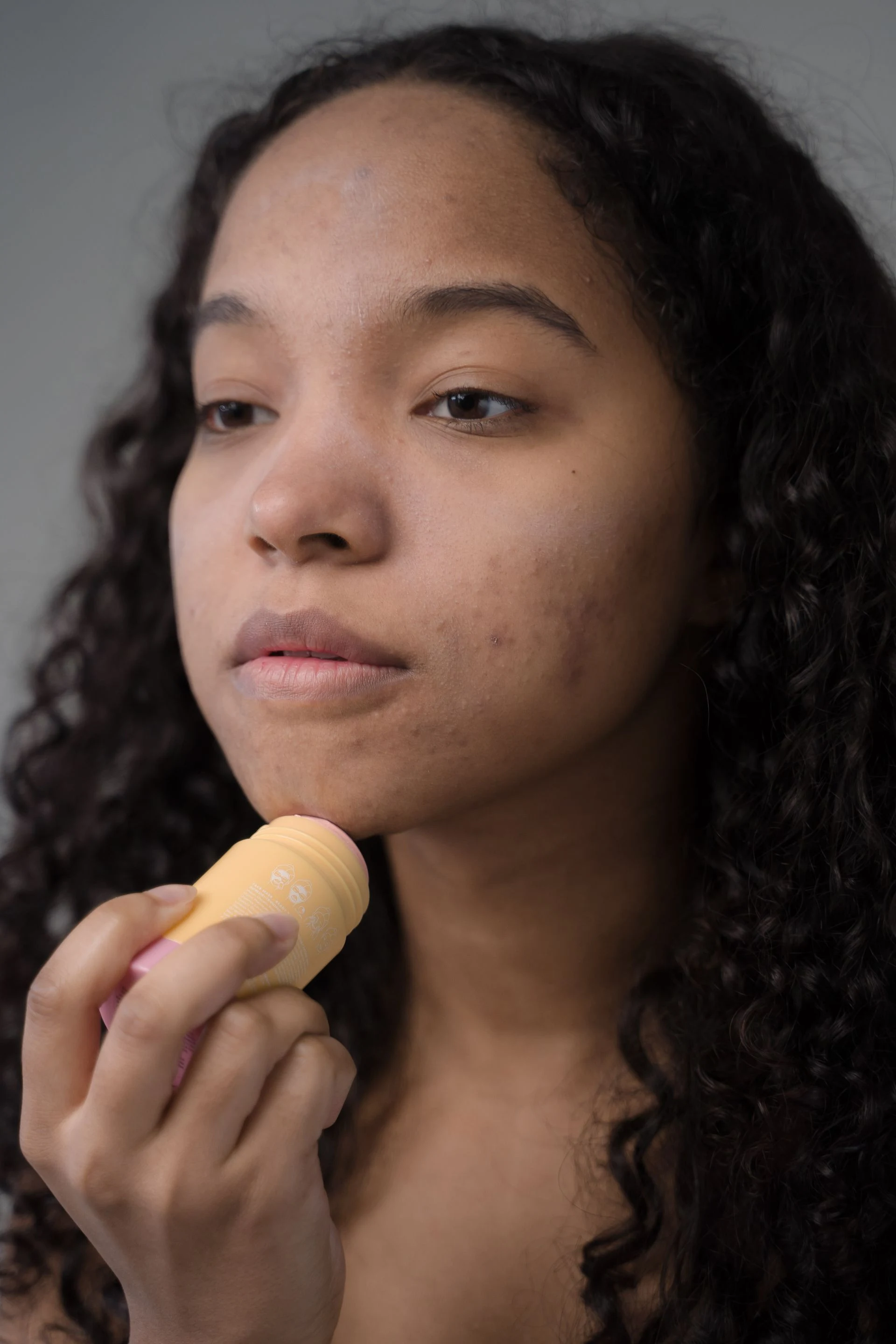 Woman applying skincare with a facial sponge