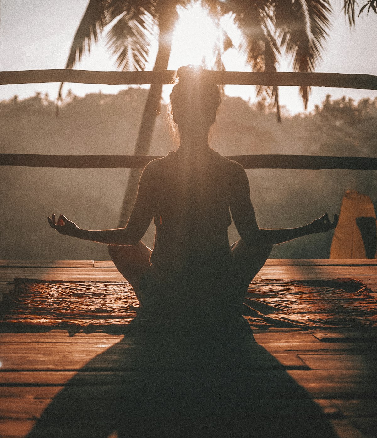 Person meditating at sunrise