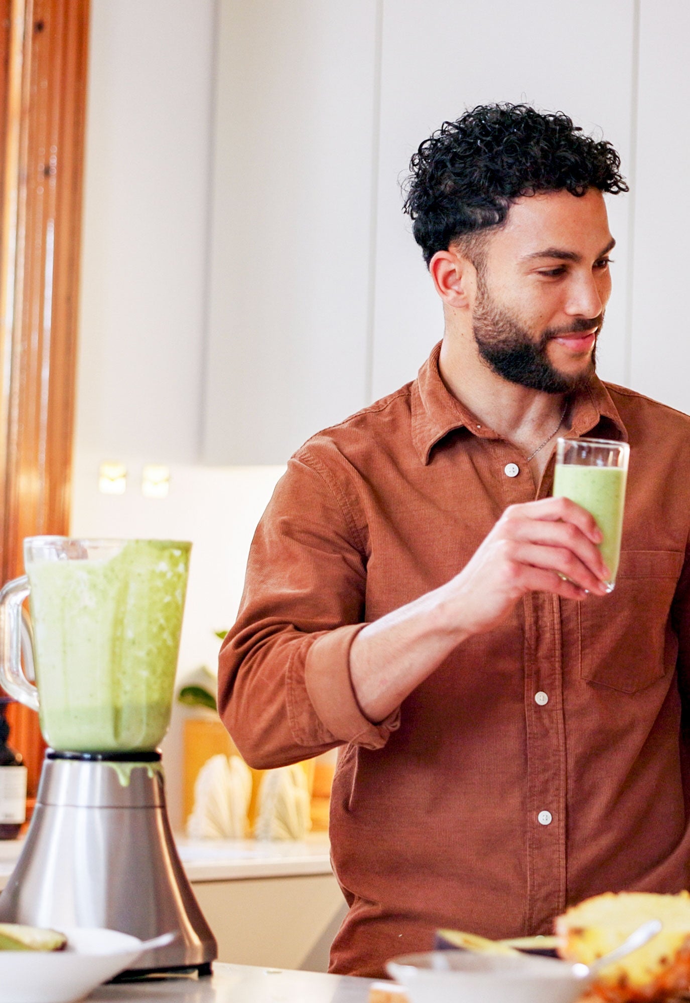 Man drinking a green smoothie